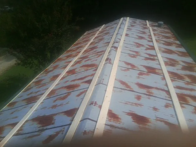 Rusted metal roof panels with new wood purlins before replacement — Storm Damage Roof Repair in Upper Falls by Roofing Brothers